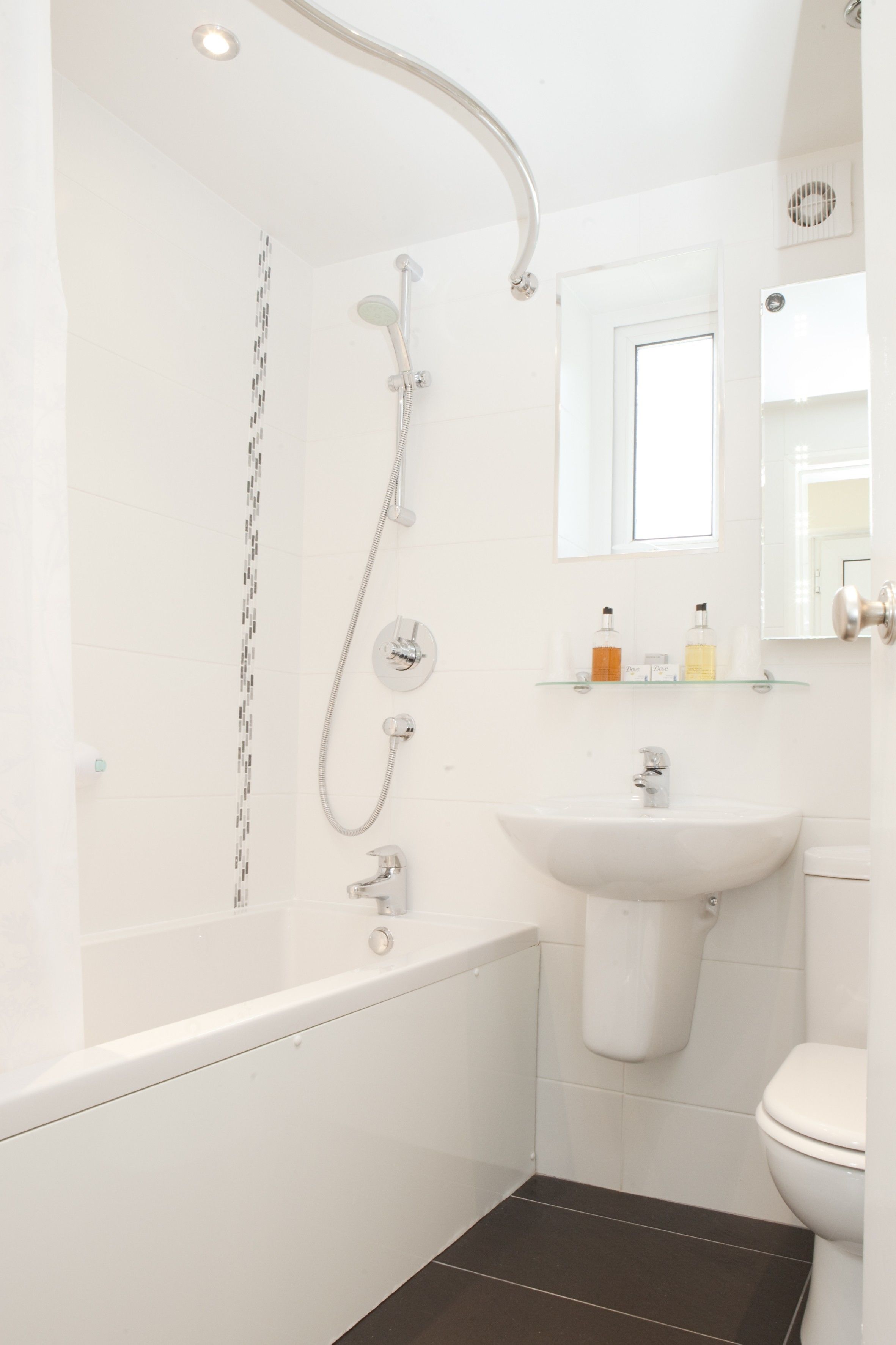 A modern bathroom with a bathtub, a shower, a sink, and a toilet.