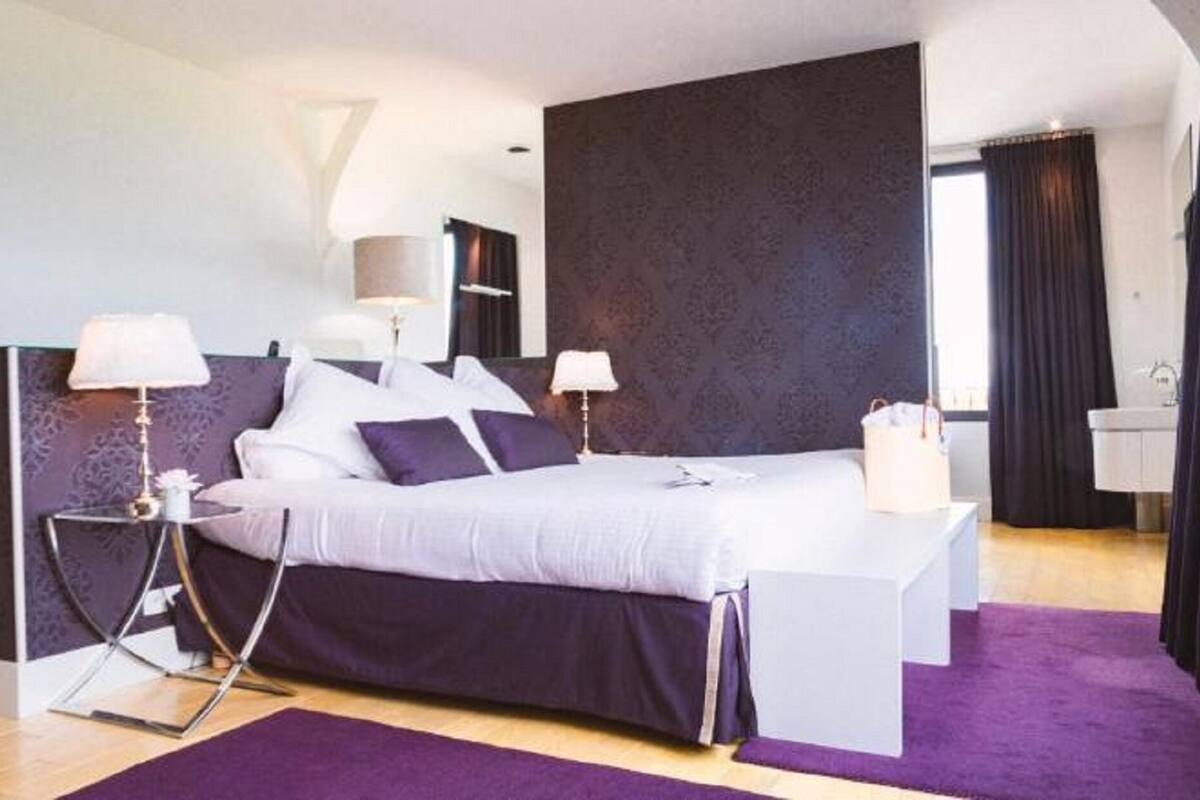 Ein modernes Schlafzimmer mit Bett, Nachttischen und einem Fenster.