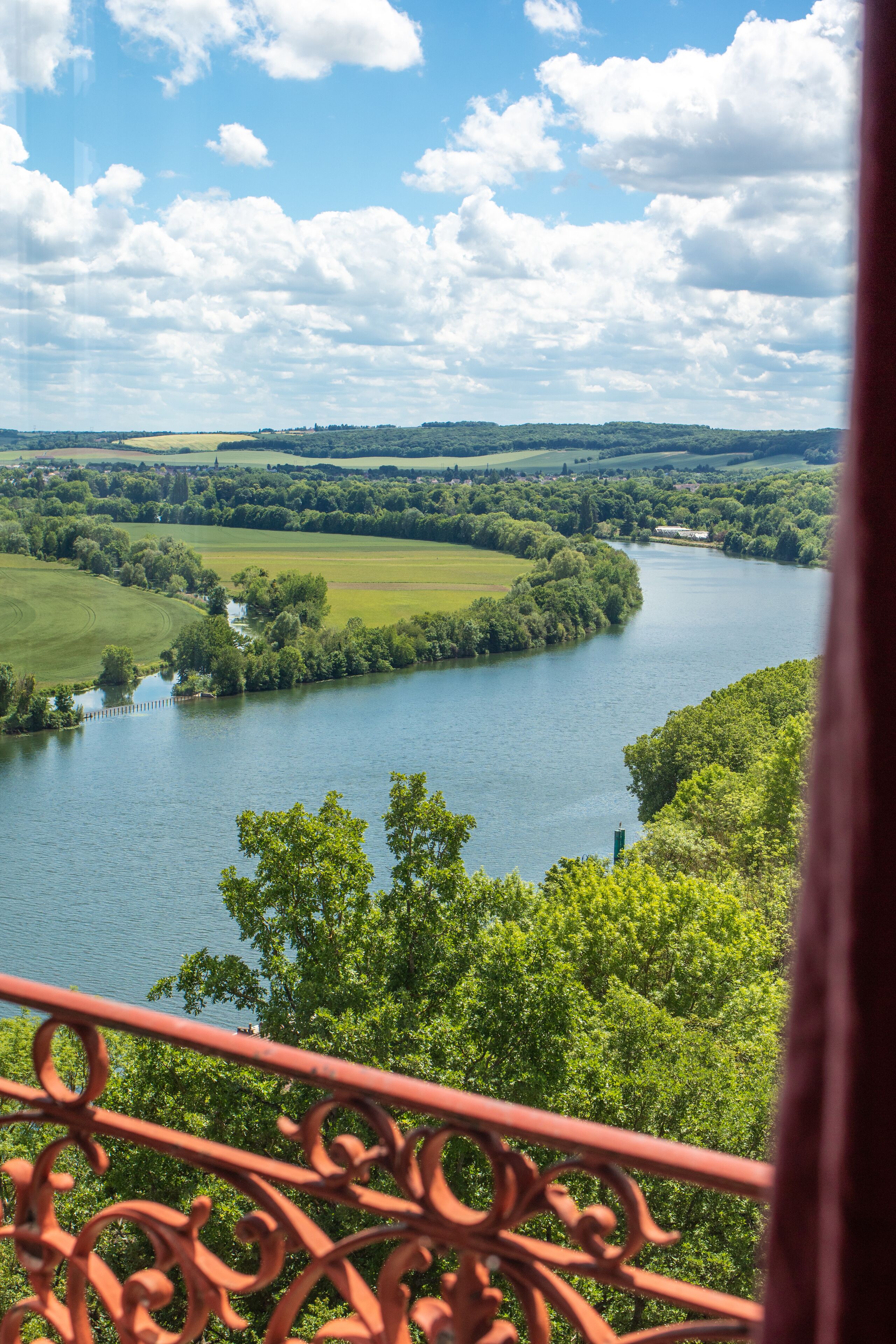 A river with a bridge, surrounded by greenery and a clear sky.