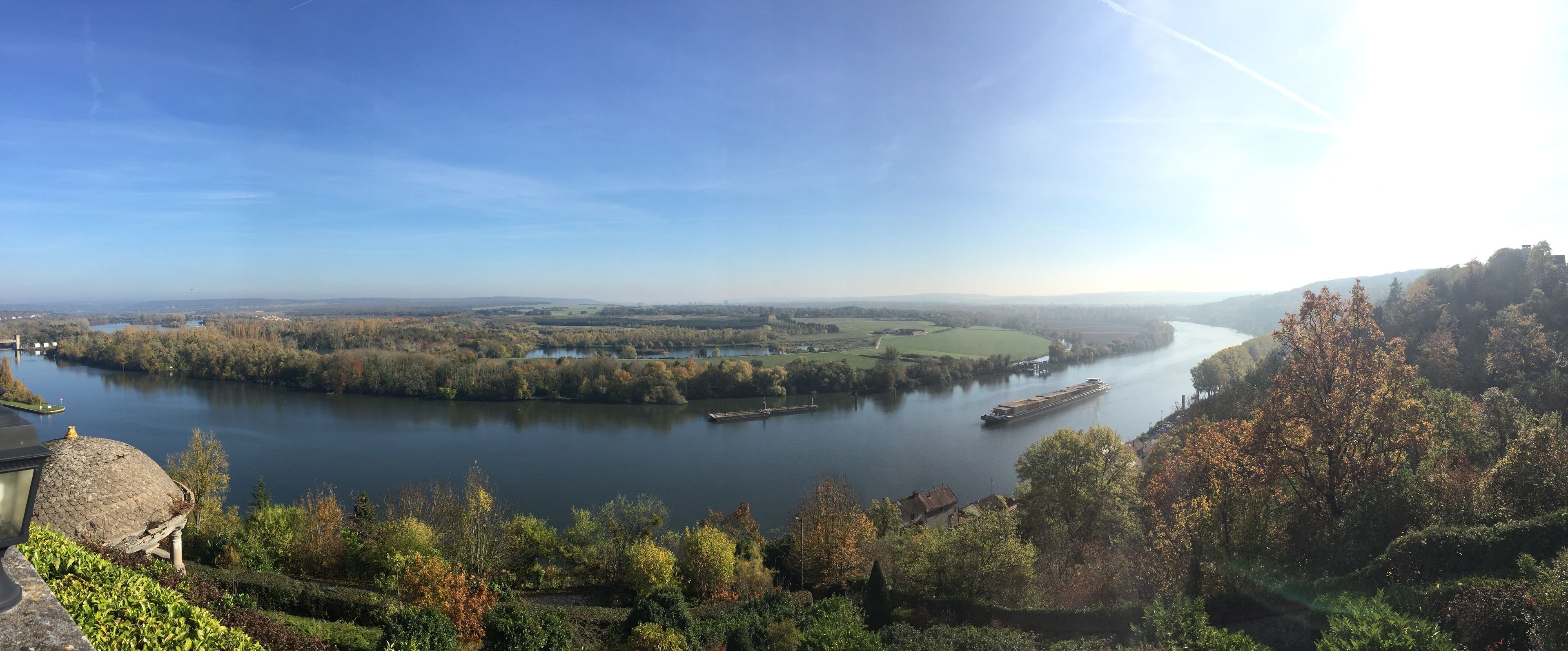 A river with a boat, surrounded by trees and a distant castle.
