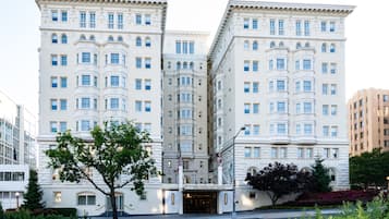 A large, white, multi-story hotel with a classic architectural style, featuring numerous windows and a prominent entrance.