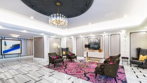 A spacious lobby with a marble floor, patterned carpet, and modern furniture. - The Churchill Hotel near Embassy Row (Washington)