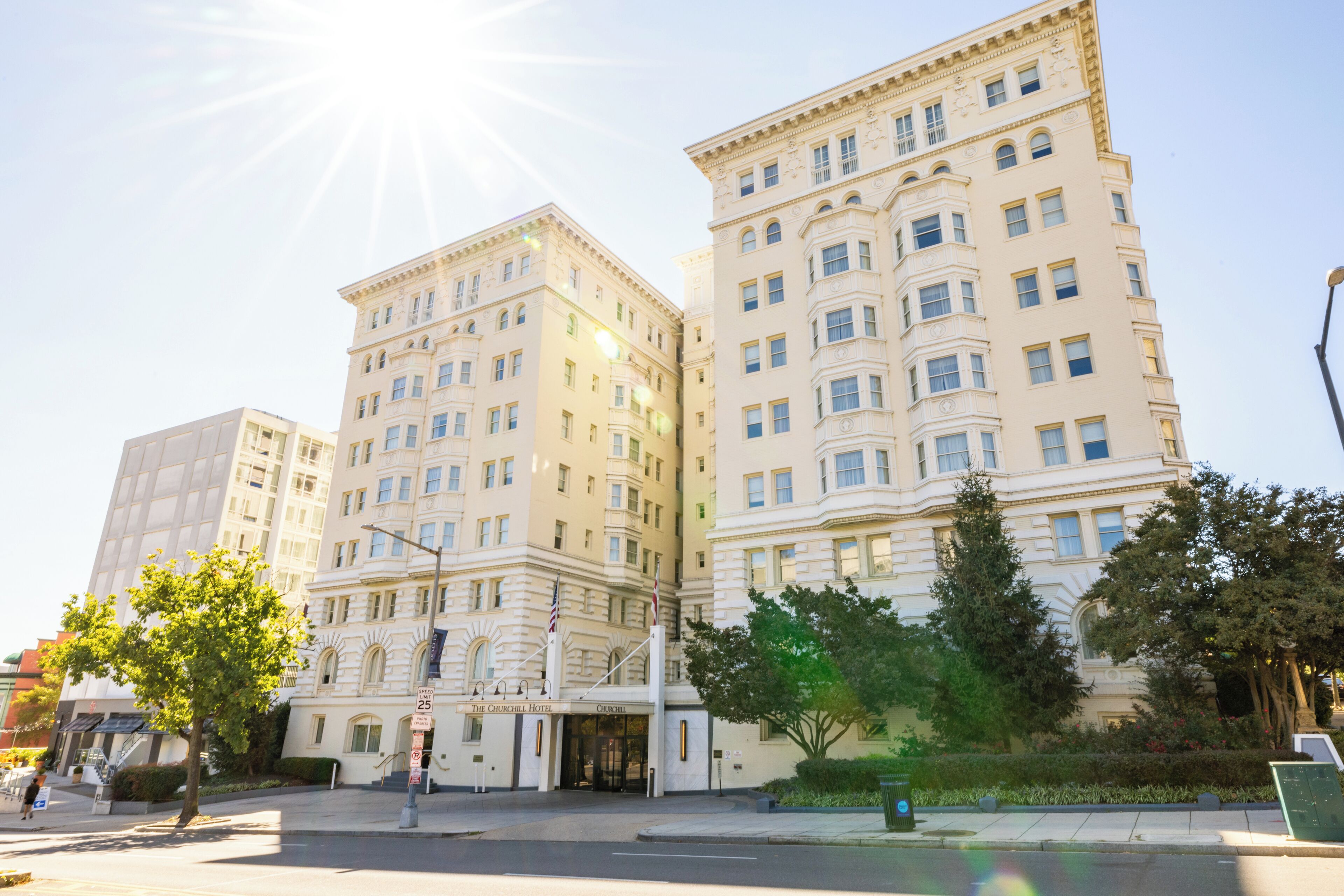 A large, multi-story building with a classic architectural style, featuring a prominent entrance and flagpole.