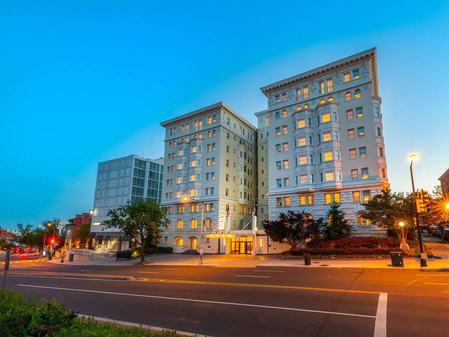 Un grand hôtel à plusieurs étages, doté d’une entrée imposante et d’une façade bien éclairée.