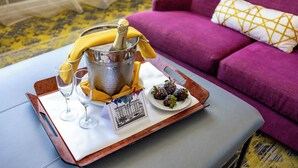 A tray with a champagne bottle, two glasses, a plate with chocolate-covered strawberries, and a card on a table. - The Churchill Hotel near Embassy Row (Washington)