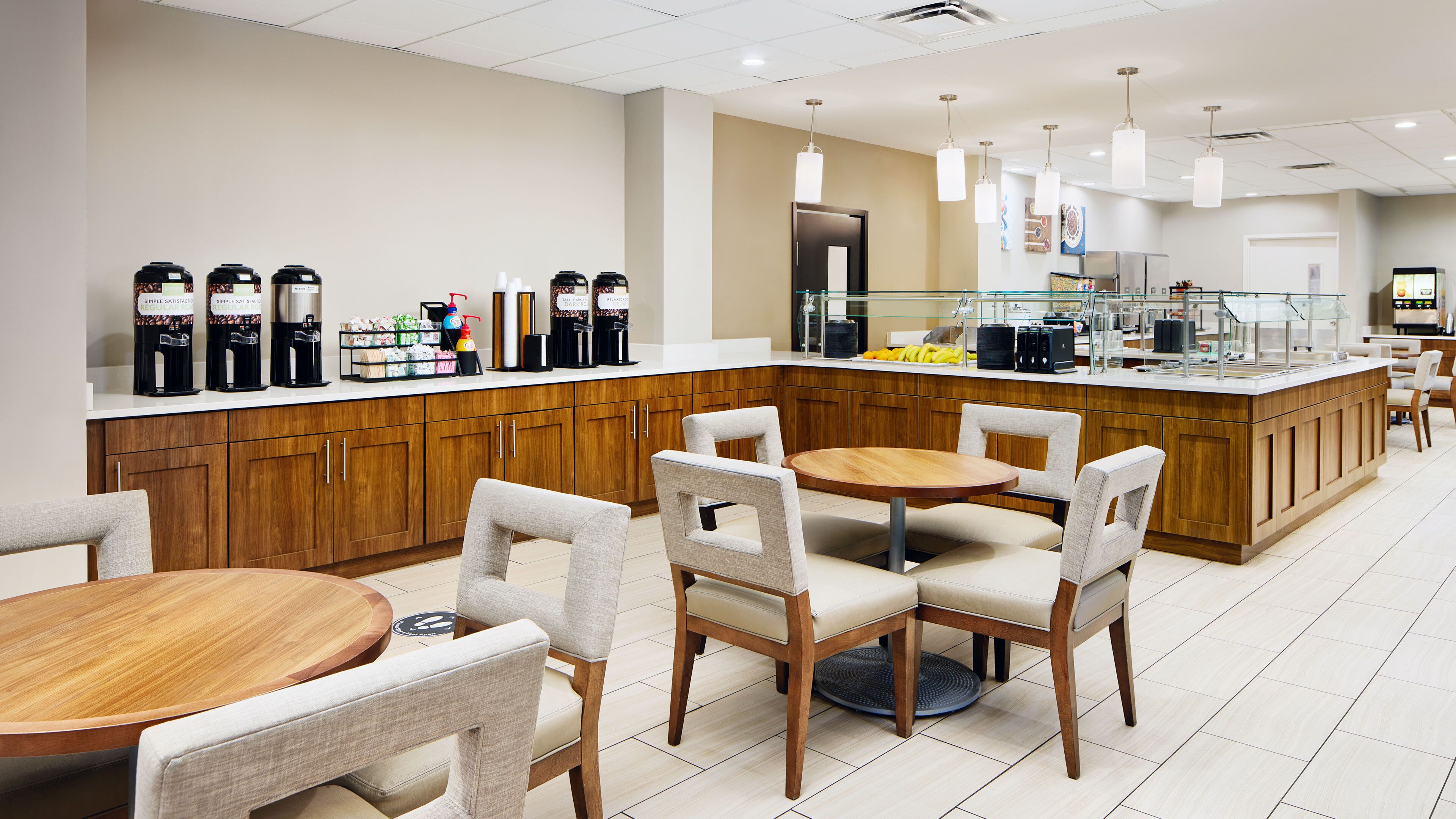 A modern hotel lobby with a central island counter, seating area, and a clean, minimalist design.