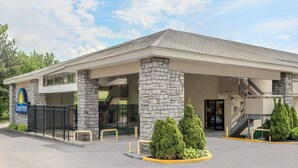 A Days Inn with a stone facade, a covered entrance, and a parking lot.