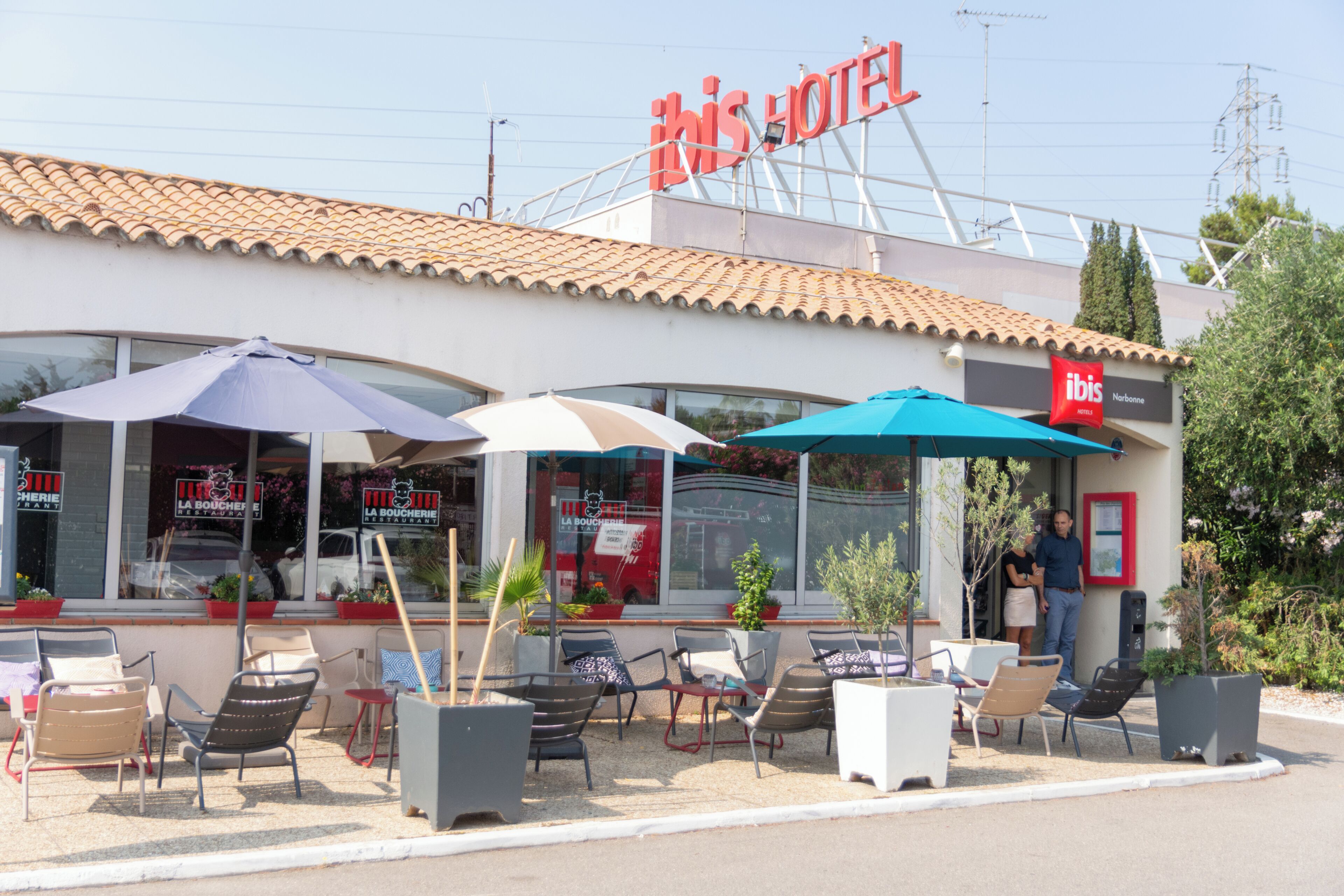 Een hotel met terras en een betegeld dak.