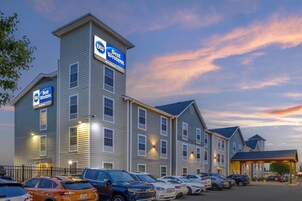 A Best Western hotel with multiple floors, a parking lot with several cars, and a covered entrance.