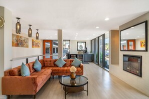 A modern living room with a sectional sofa, a glass coffee table, and artwork on the walls. - La Luna Inn, an Ascend Collection Hotel (San Francisco)