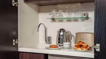 A kitchen with a stainless steel sink, a coffee maker, and a toaster.