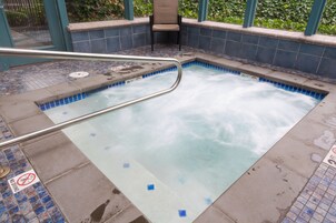 Un jacuzzi con barandilla metálica, bordes con azulejos y un cartel de 'No natación'.