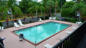Une piscine rectangulaire équipée d’un poste de surveillance pour sauveteur et d’un fauteuil roulant.