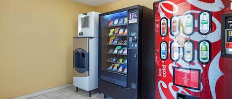 A vending machine with a Coca-Cola logo, a water dispenser, and a refrigerated unit with snacks.