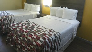 A hotel room with two single beds, each with white bedding and a headboard. There is a wall-mounted light fixture above the beds, and a framed picture on the wall to the left. -  Red Roof Inn Hampton Coliseum (Hampton)