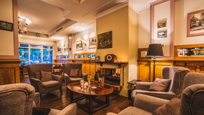 Una sala de estar acogedora con varios sillones, una mesa de centro de madera y una chimenea.
