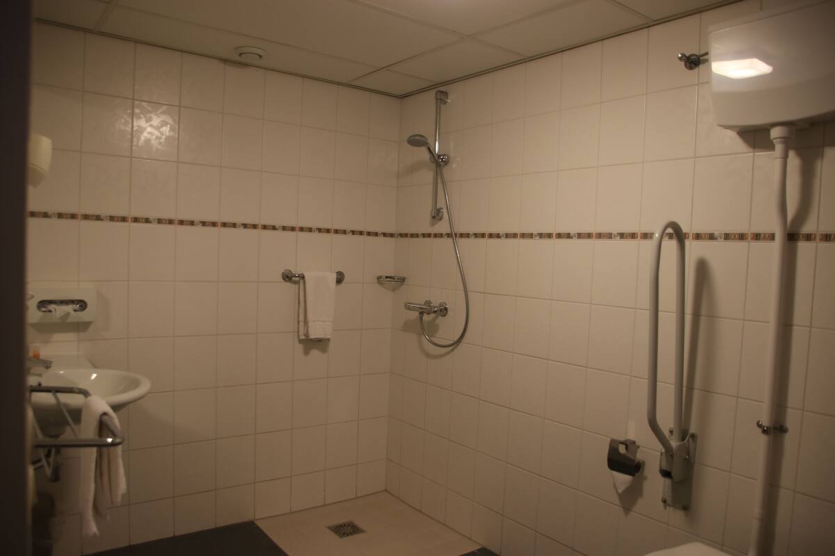 A bathroom with a shower, sink, and toilet.