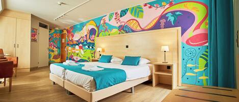 A hotel room with a large bed, two bedside tables, and a colorful mural on the wall.