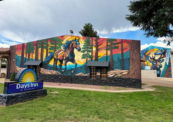 A Days Inn with a mural of a horse and forest on the building's facade.