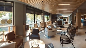 A spacious lounge area with modern furniture, large windows, and a wooden ceiling design. - Novotel Bordeaux Centre Gare Saint Jean (Bordeaux)