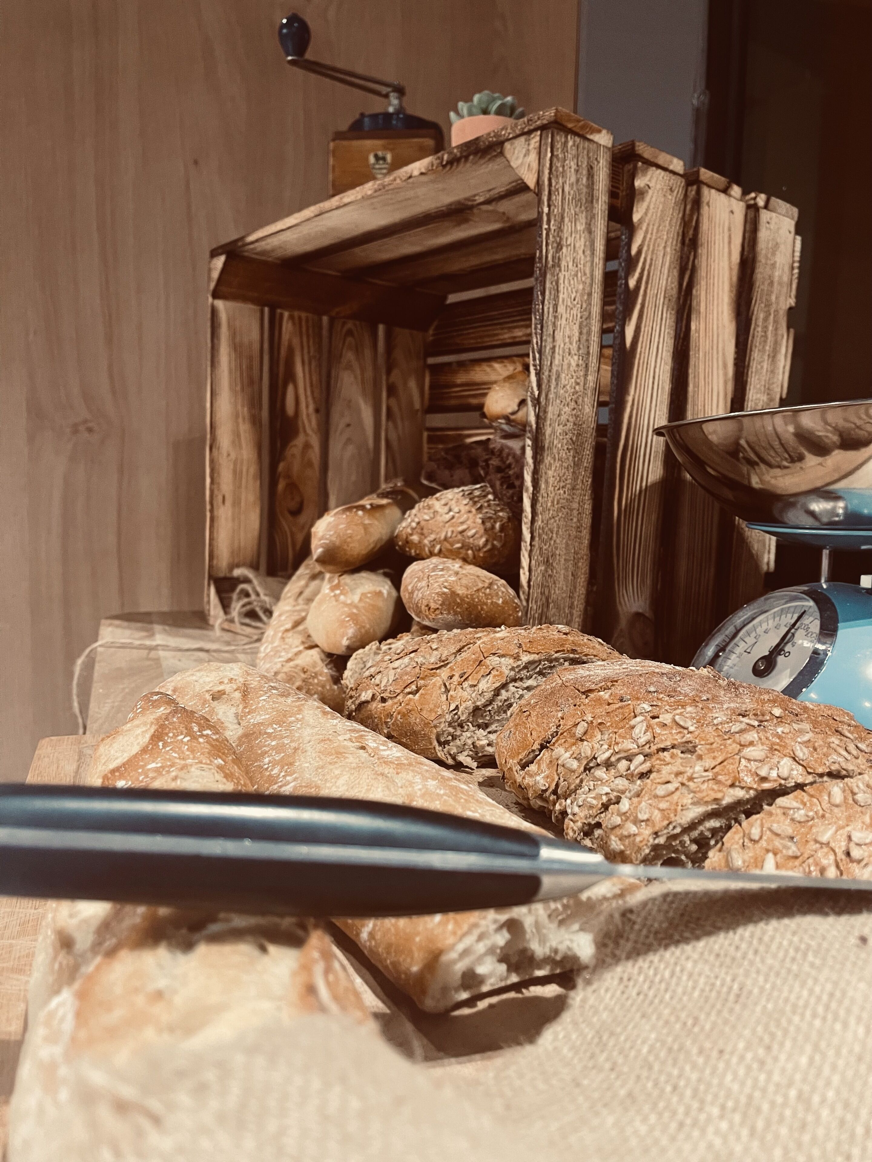 Eine hölzerne Brotkiste, gefüllt mit verschiedenen Brotsorten.