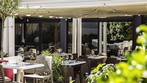 An outdoor dining area with tables, chairs, and string lights. - Novotel Bordeaux Centre Gare Saint Jean (Bordeaux)