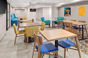 Relax in this inviting space with a dining area, comfortable seating, and a mounted TV.