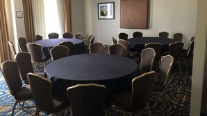A conference room with two round tables, each surrounded by chairs.