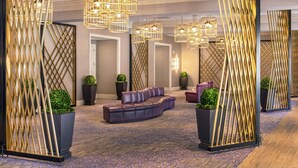 Eine moderne Lobby mit einer Ledersofa, dekorativer Beleuchtung und einem gemusterten Teppich.