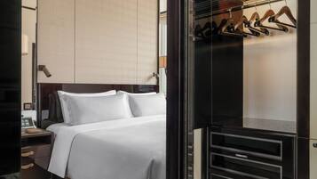 A hotel room with a bed, a nightstand, a wardrobe, and a mirror.