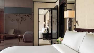 A hotel room with a bed, a desk, a chair, and a mirror.