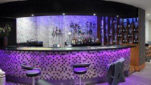 A bar area with a curved counter, purple mosaic tiles, and a wine rack in the background. - Hylands Hotel (Coventry)