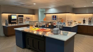 Un espace buffet avec un coin où les clients peuvent se servir eux-mêmes, un réfrigérateur et un distributeur de café.