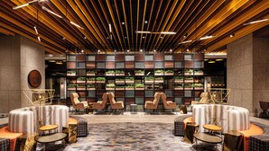 A modern lounge area with tiered seating, a patterned floor, and a backdrop of greenery. - JEN Singapore Tanglin by Shangri-La (Singapore)