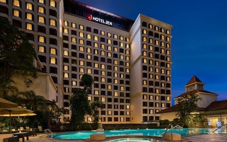 A hotel with multiple floors, a swimming pool, and outdoor seating areas.