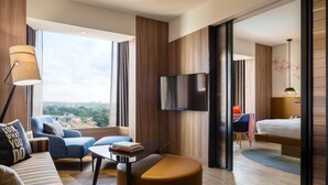 A modern hotel room with a sofa, armchair, ottoman, and a bed. - JEN Singapore Tanglin by Shangri-La (Singapore)