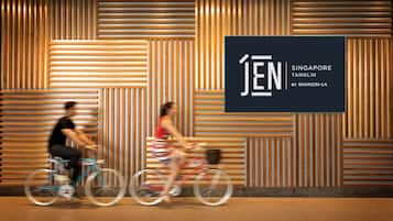 Un interior moderno con listones de madera en las paredes y un gran cartel que dice 'JEN Singapore Tanglin by Shangri-La'.
