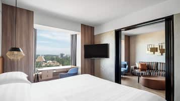 Una habitación de hotel moderna con una cama grande, un escritorio y un televisor.