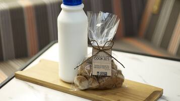 Una botella de agua, una bolsa de galletas y una bandeja de madera sobre una mesa.