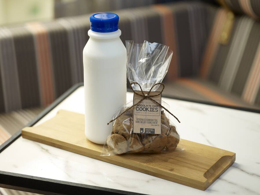 Una botella de agua, una bolsa de galletas y una bandeja de madera sobre una mesa.