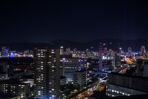 A nighttime cityscape with illuminated buildings and a bridge.