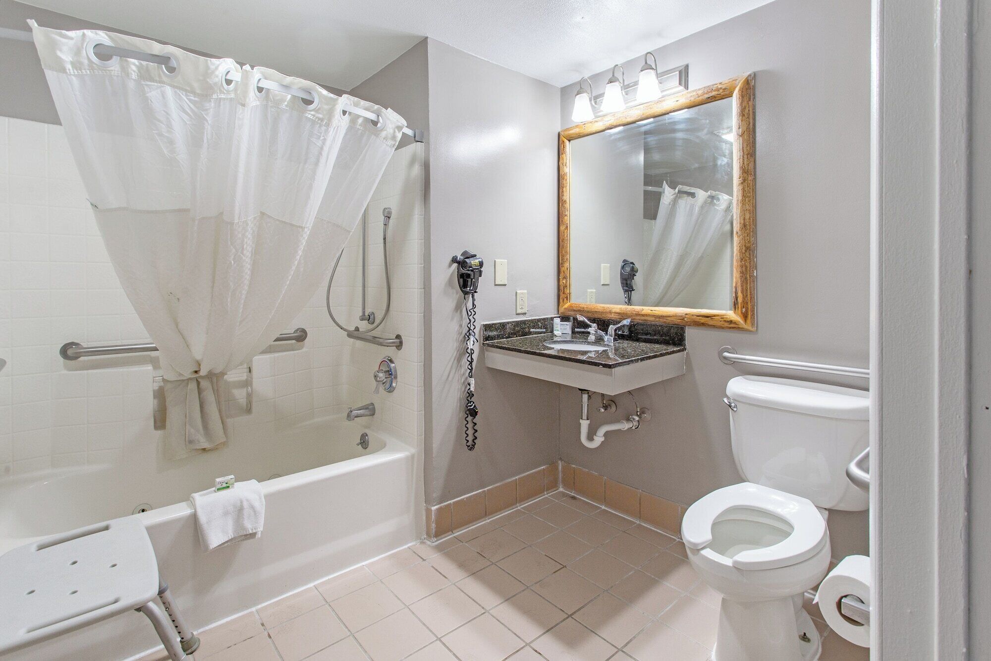 Un baño con bañera, lavamanos, inodoro y ducha con cortina.