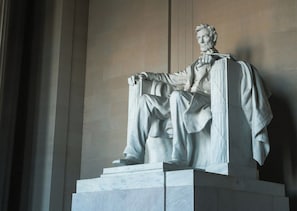 A marble statue of a seated figure on a pedestal. - The Beacon at Embassy Row (Washington)