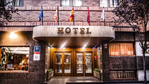 A hotel entrance with a marble facade, double doors, and a sign above. - B&B Hotel Zaragoza Royal (Zaragoza)