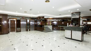 A modern hotel lobby with marble flooring, a reception desk, and two elevators. - B&B Hotel Zaragoza Royal (Zaragoza)