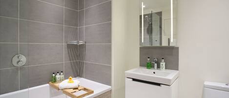 Ein modernes Badezimmer mit einer Badewanne, einem Waschbecken und einem Spiegel.