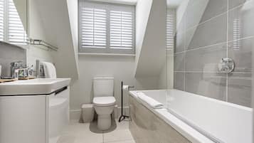 A modern bathroom with a toilet, sink, and bathtub.