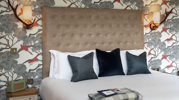 Ein ordentlich bezogenes Bett mit einem geblatteten Kopfteil, zwei Nachttischen und einer Wand mit einem floralen Wandpapier-Design.