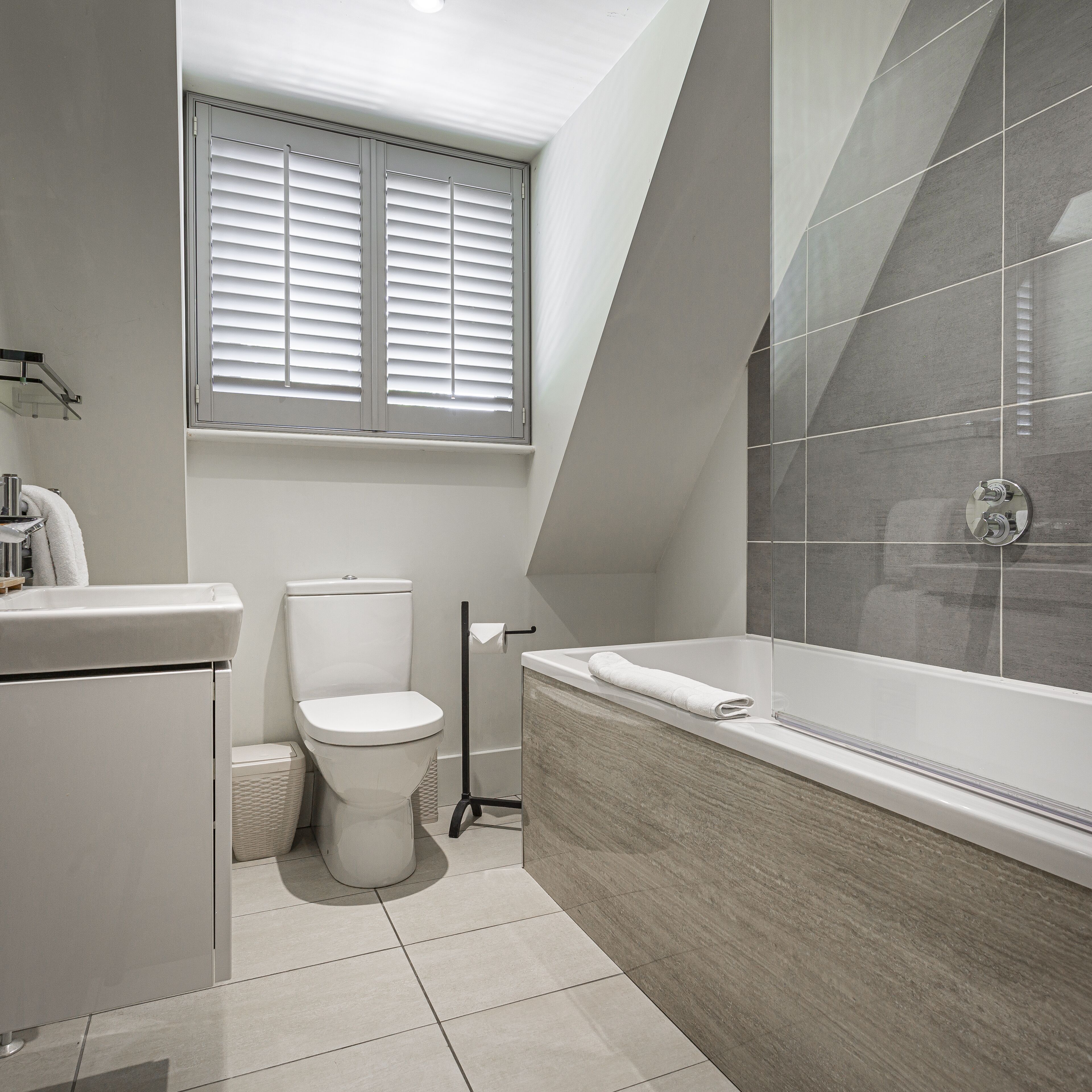 A modern bathroom with a toilet, sink, and bathtub.