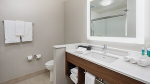 A modern bathroom with a white sink, mirror, and towel rack.